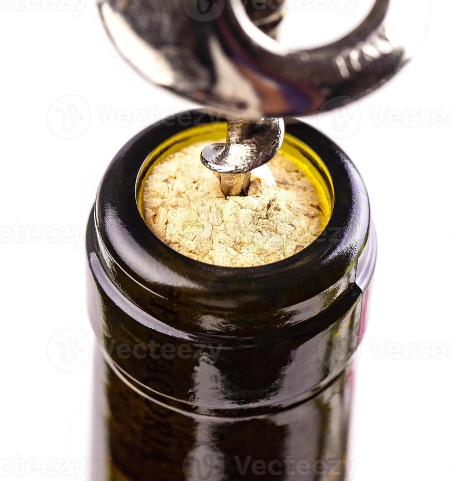 The opening a wine bottle with a cork screw photo