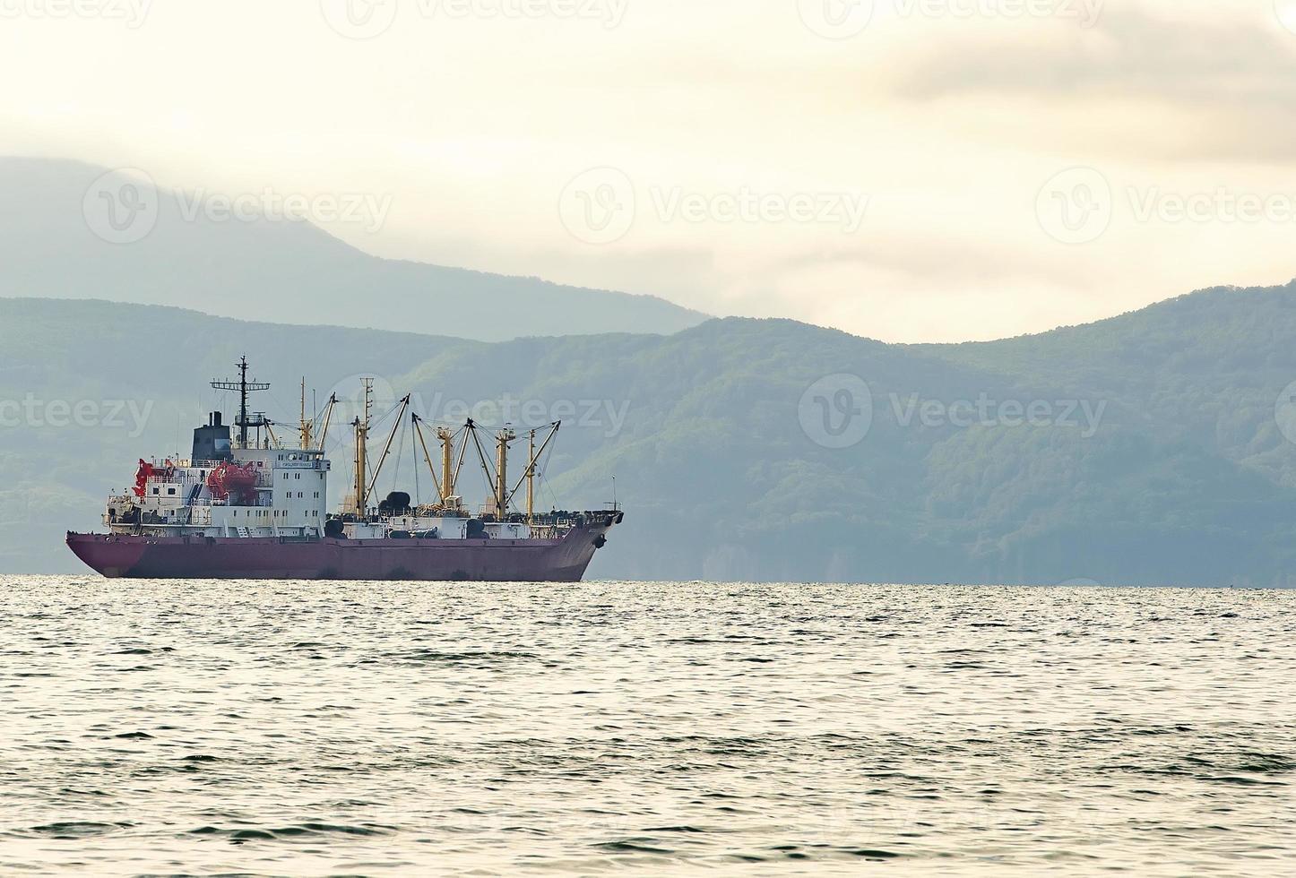 fishing boat in gray morning on Pacific ocean off the coast of the Kamchatka Peninsula photo