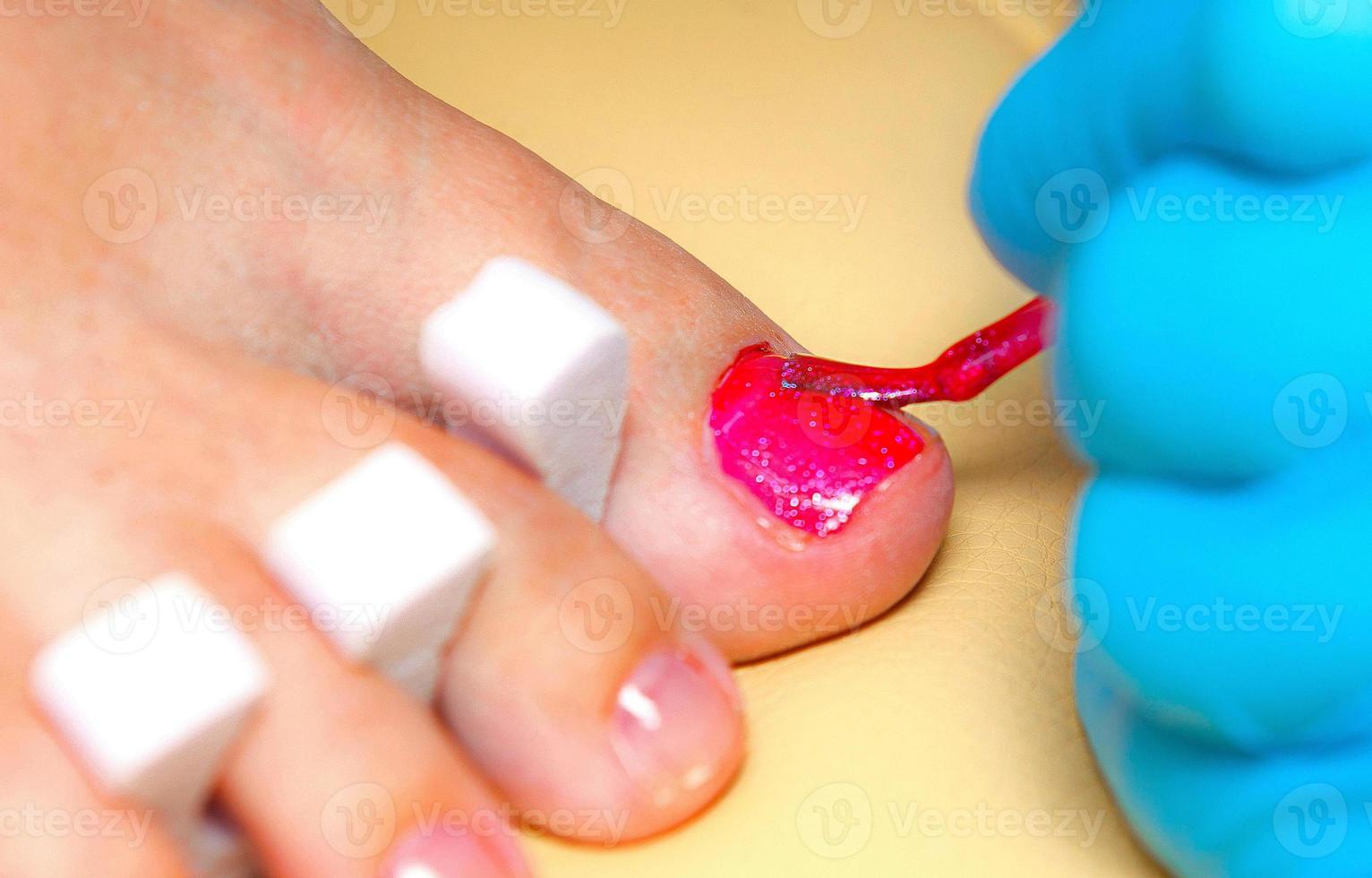 el maestro hace una pedicura en un salón de belleza foto