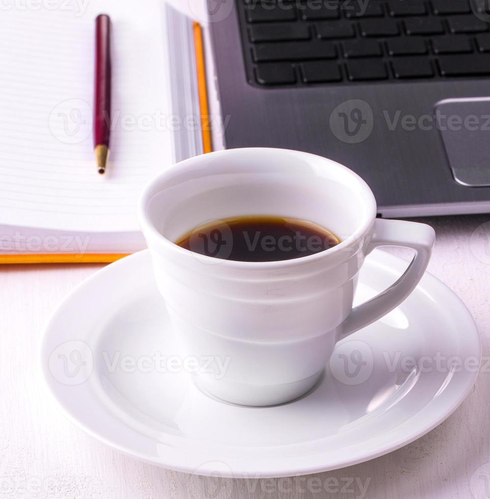 laptop, notebook with a cup of coffee and a pencil photo