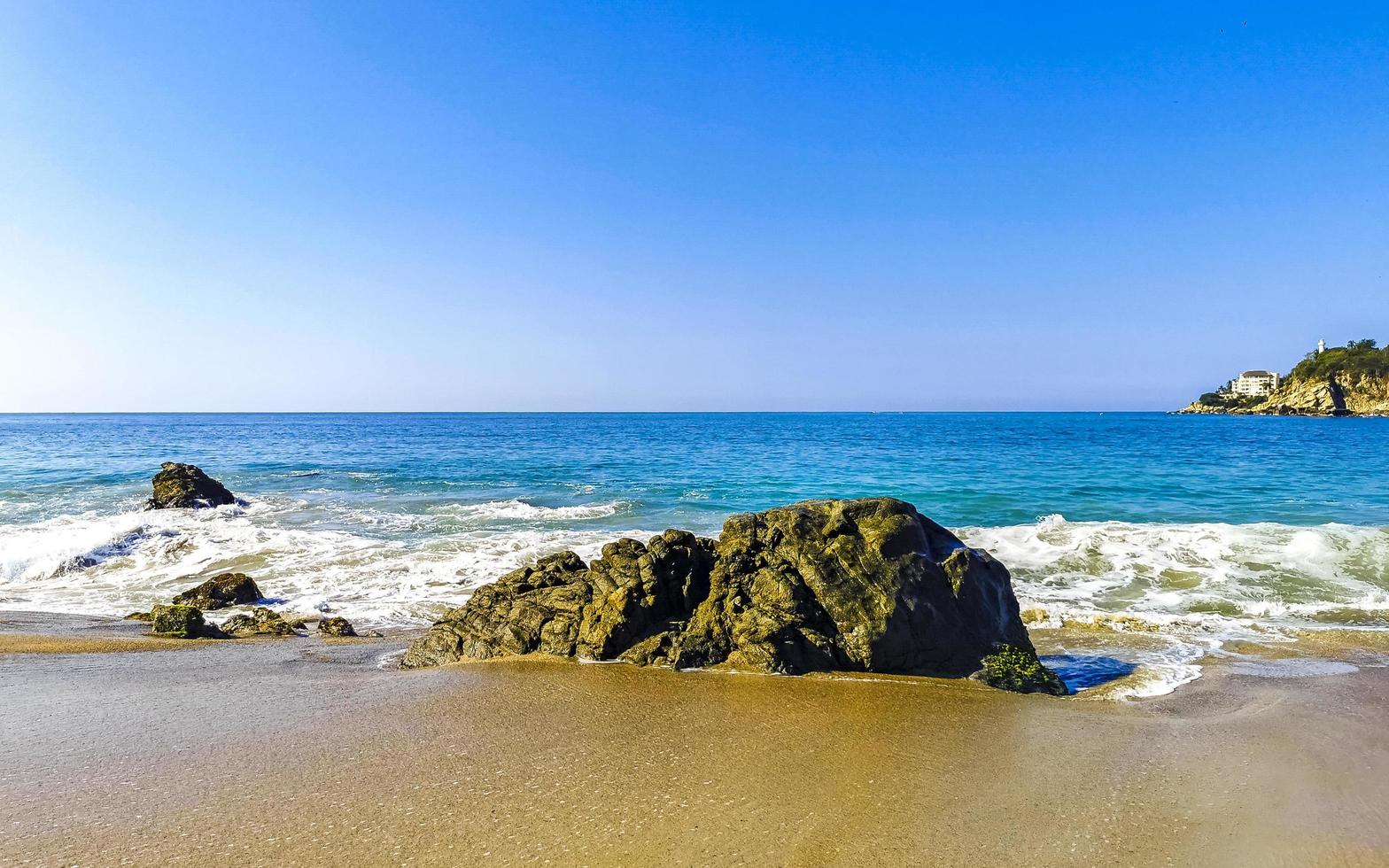 Big surfer waves and rocks at beach Puerto Escondido Mexico. photo