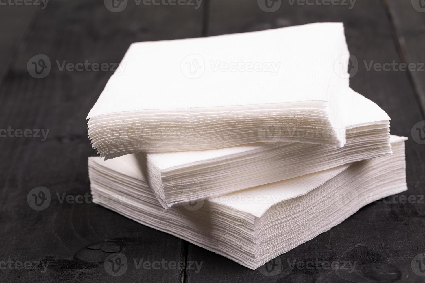 The white paper napkin on old black wooden table photo