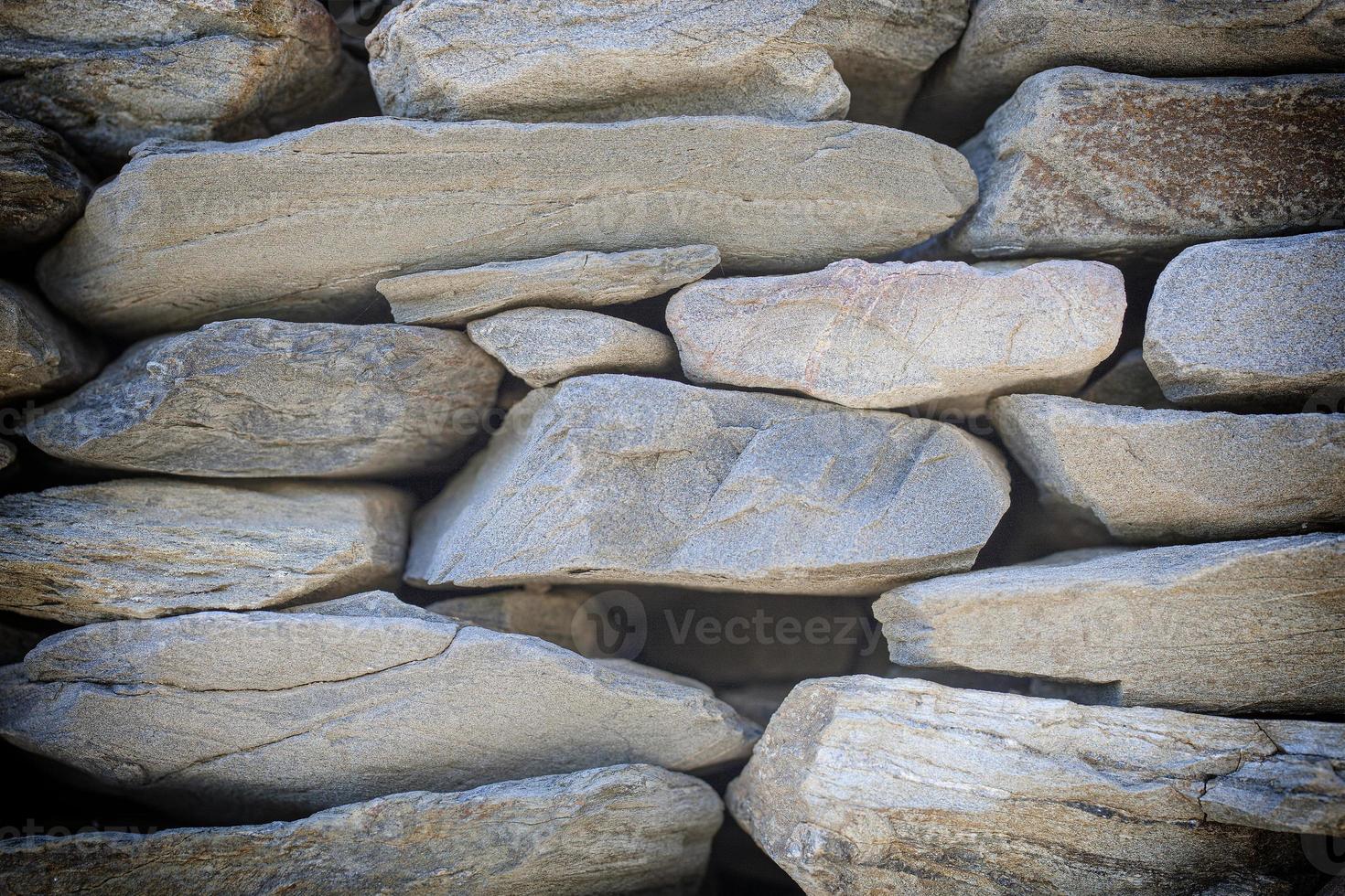 texture of the stone-brick multi-colored masonry with large cracks and a rough coating photo