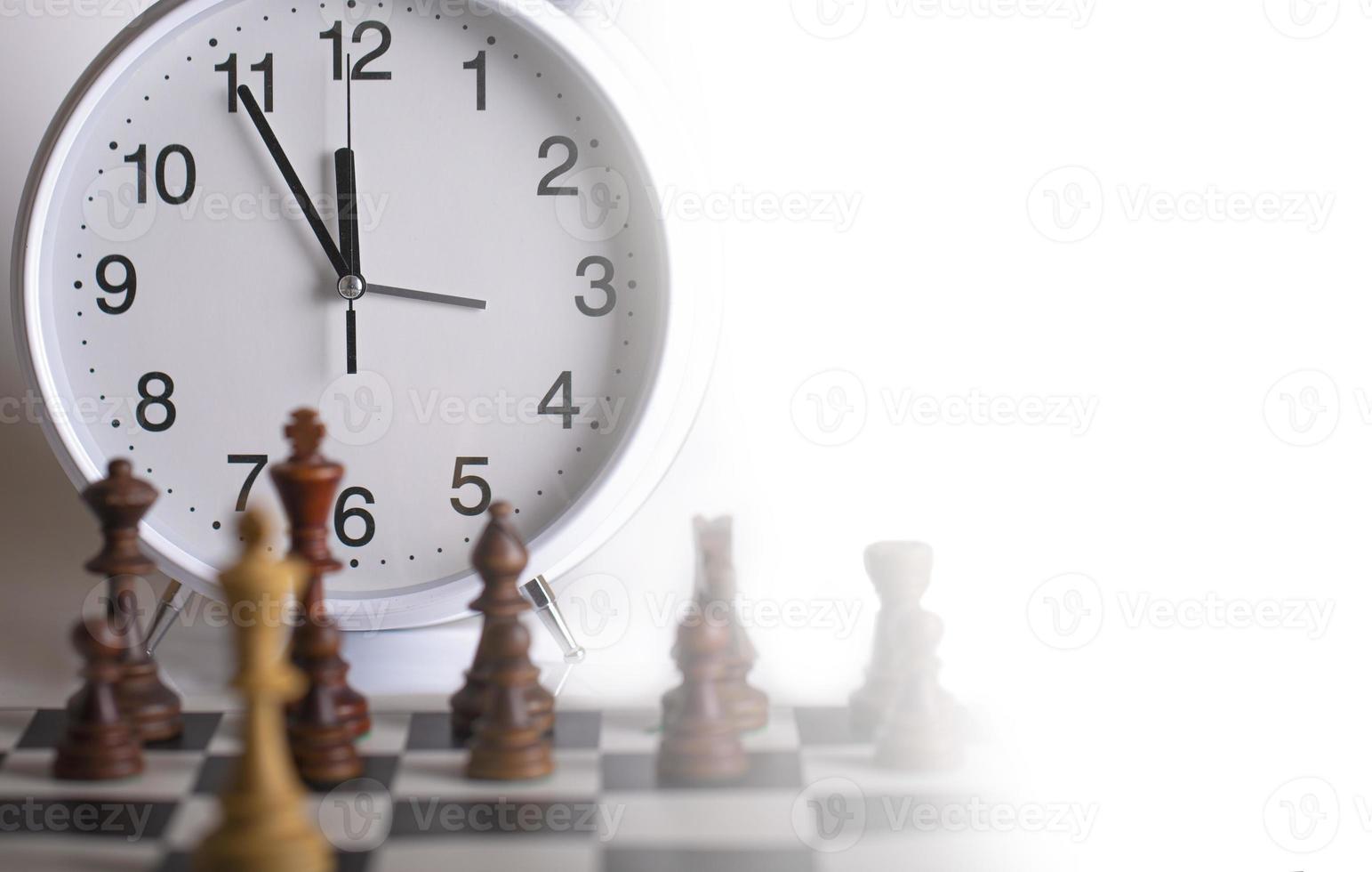Clock and Chess pieces on a chessboard. as background. The concept of playing and winning a chess tournament photo