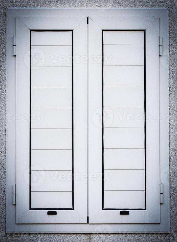 white closed shutters on windows on white wall. Close up photo