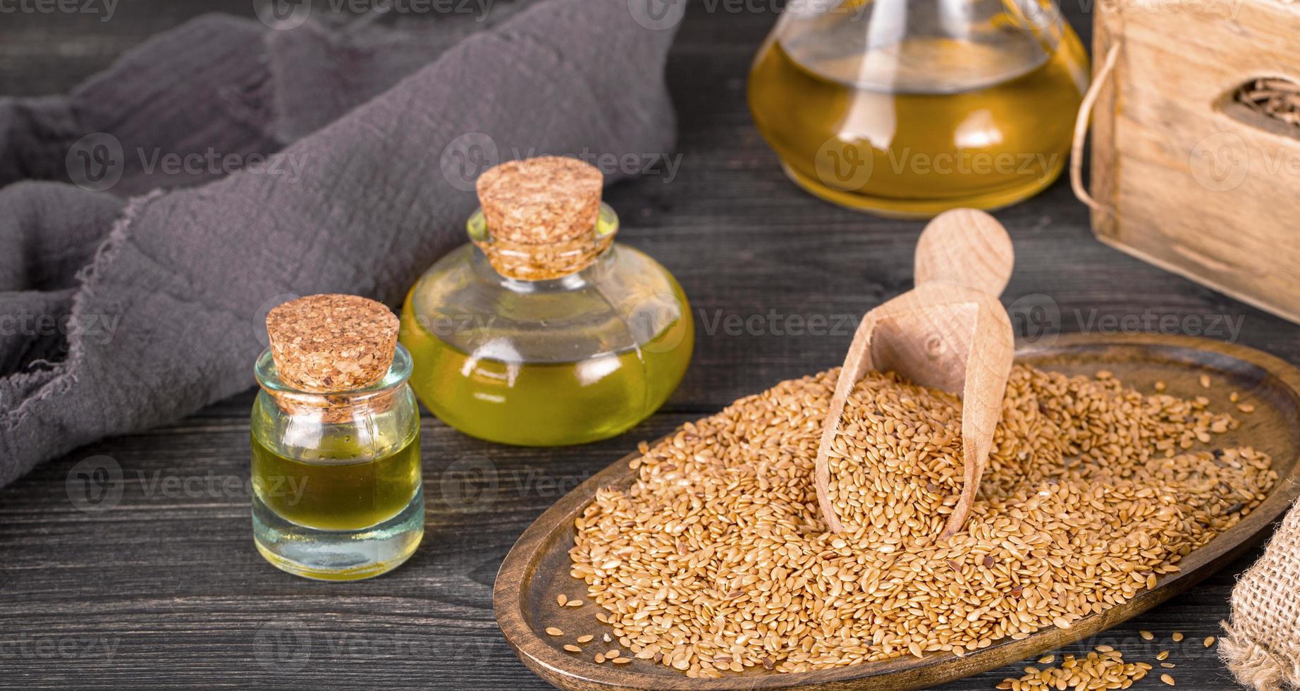 olive oil and sesame seeds on wooden surface photo