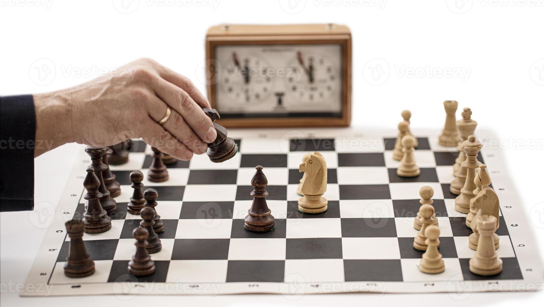 chess board with clock and figures on white background, selective focus photo