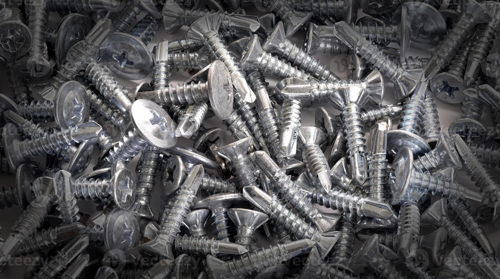 new bunch of small metal screws sa background photo