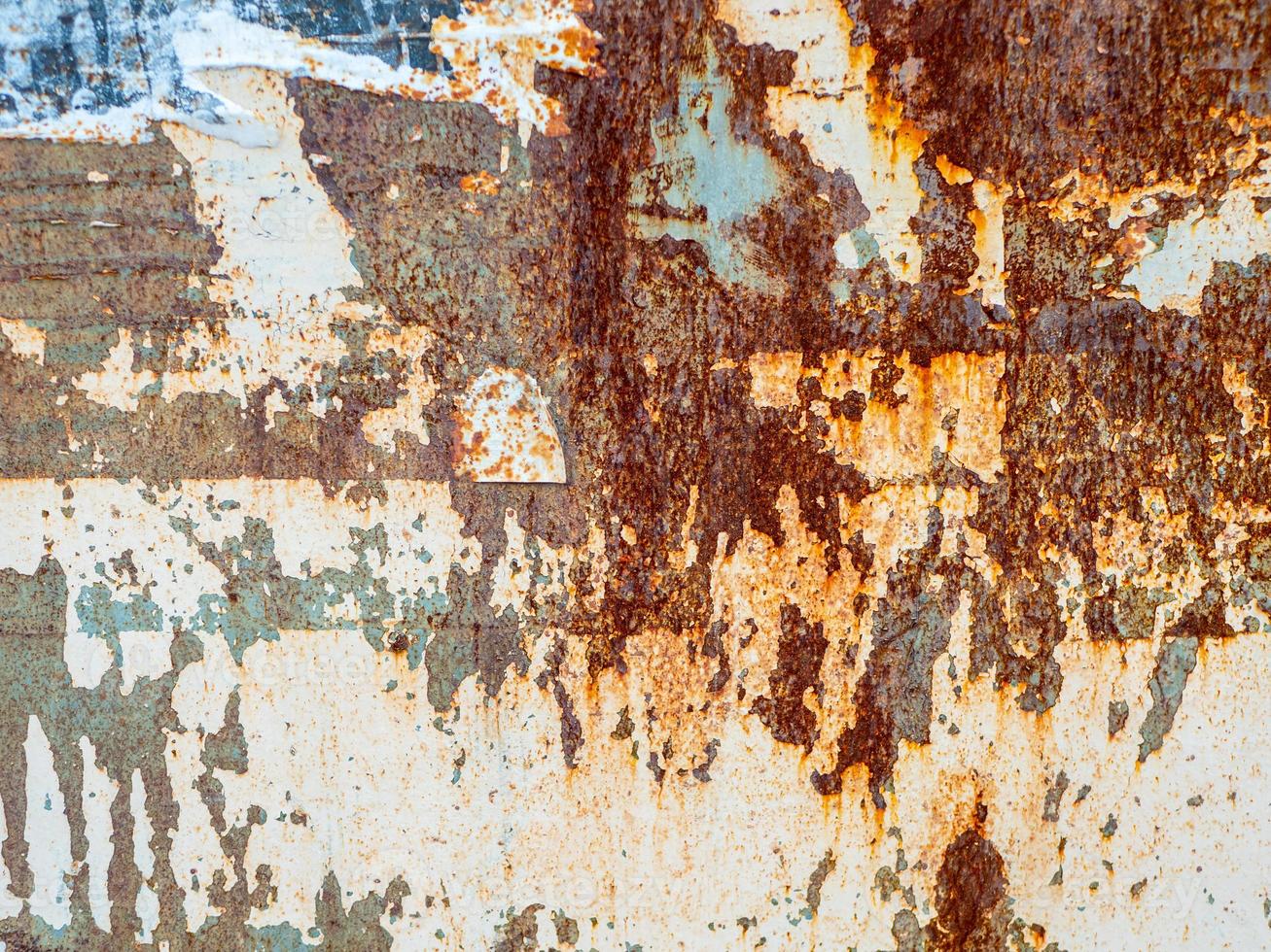 Rusty metal grunge abstract background. Rusted steel tin abstract pattern with torn paper posters. photo