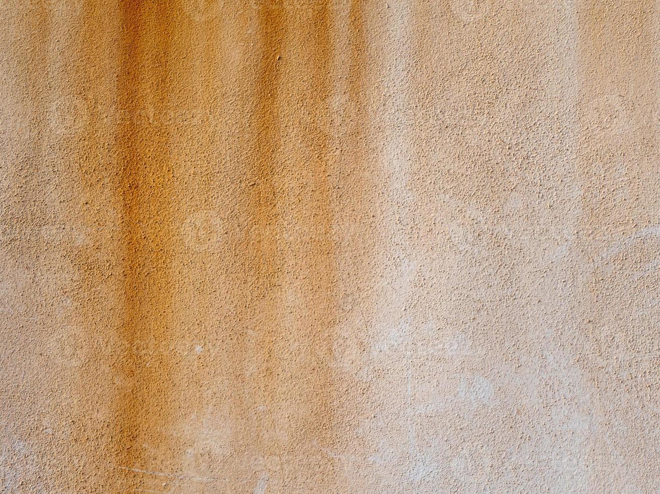 Abstract grunge textured background. Beige rough concrete wall with rusty smudges photo