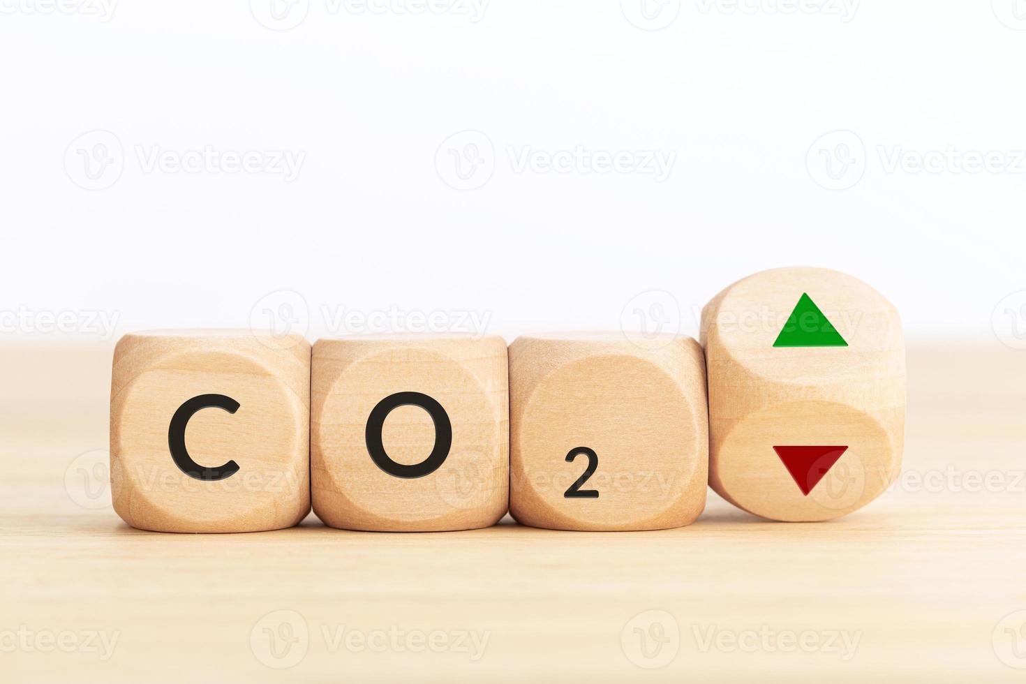 CO2 emissions up or down concept. Symbol on wooden blocks and turning dice with up and down arrows. Copy space photo