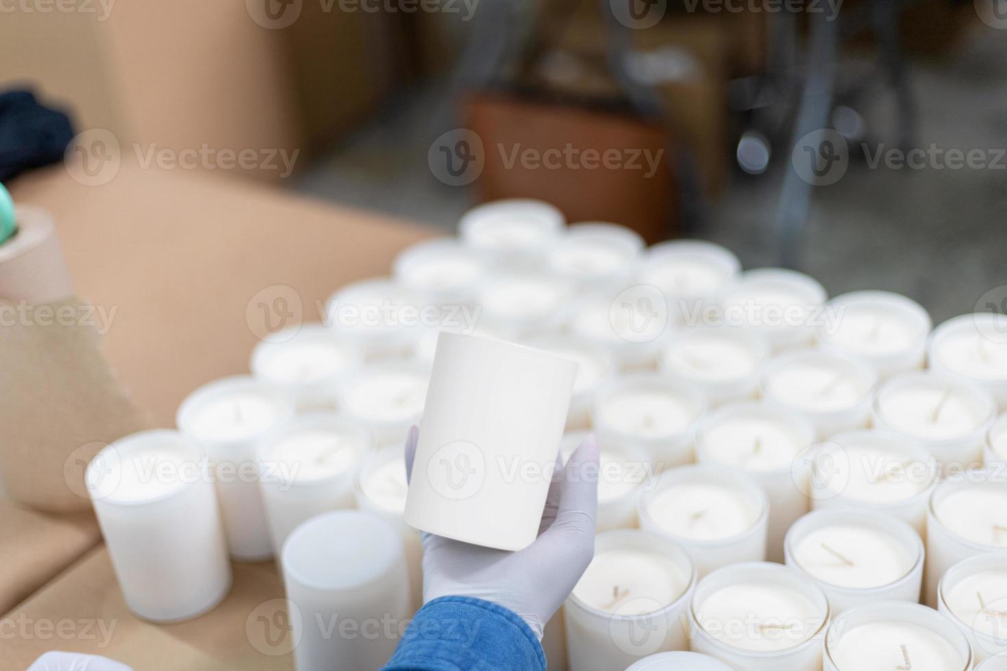 mujer sosteniendo una vela en un almacén usando guantes foto