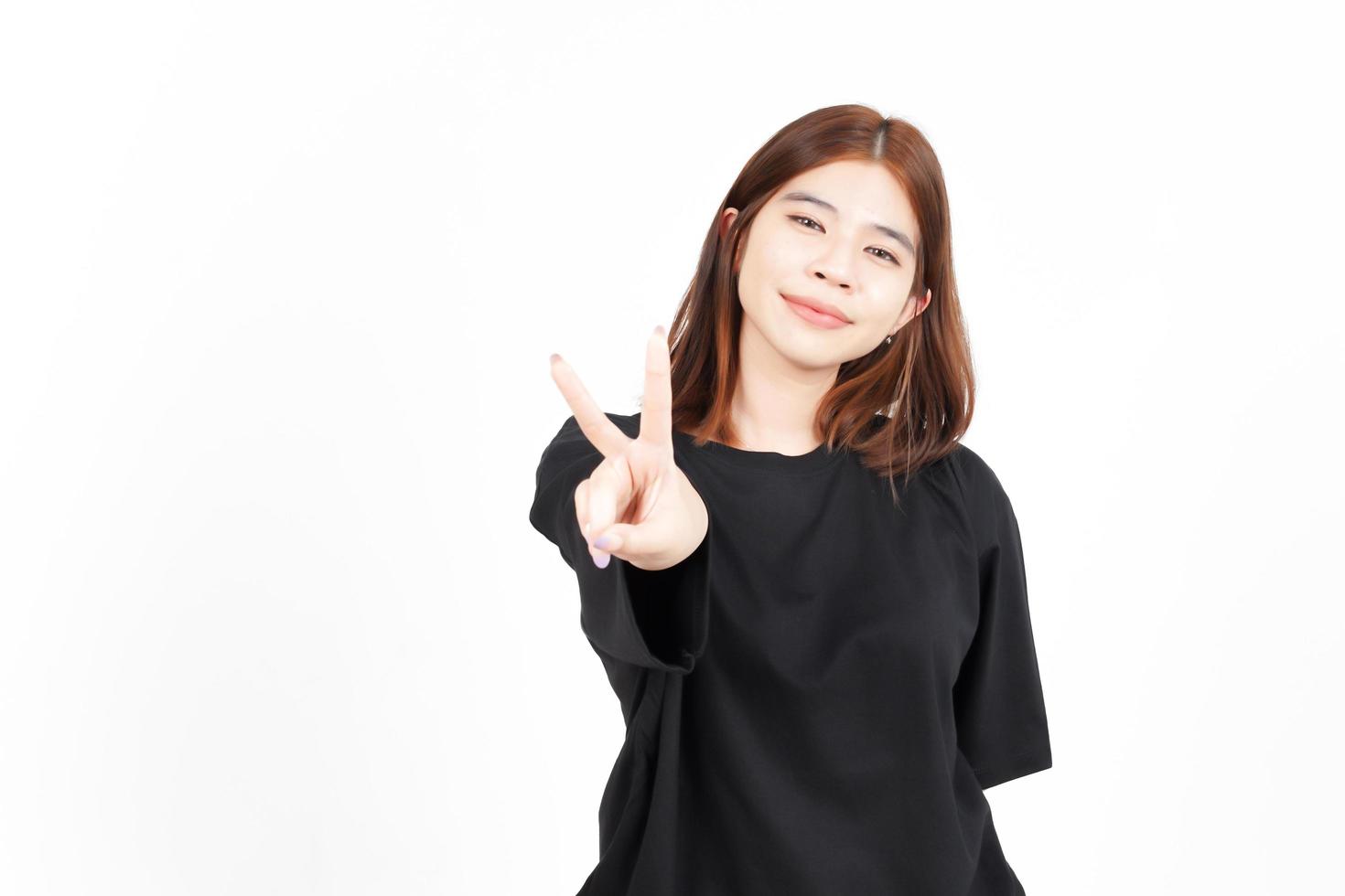 mostrando el signo de la paz y la sonrisa de una hermosa mujer asiática aislada de fondo blanco foto