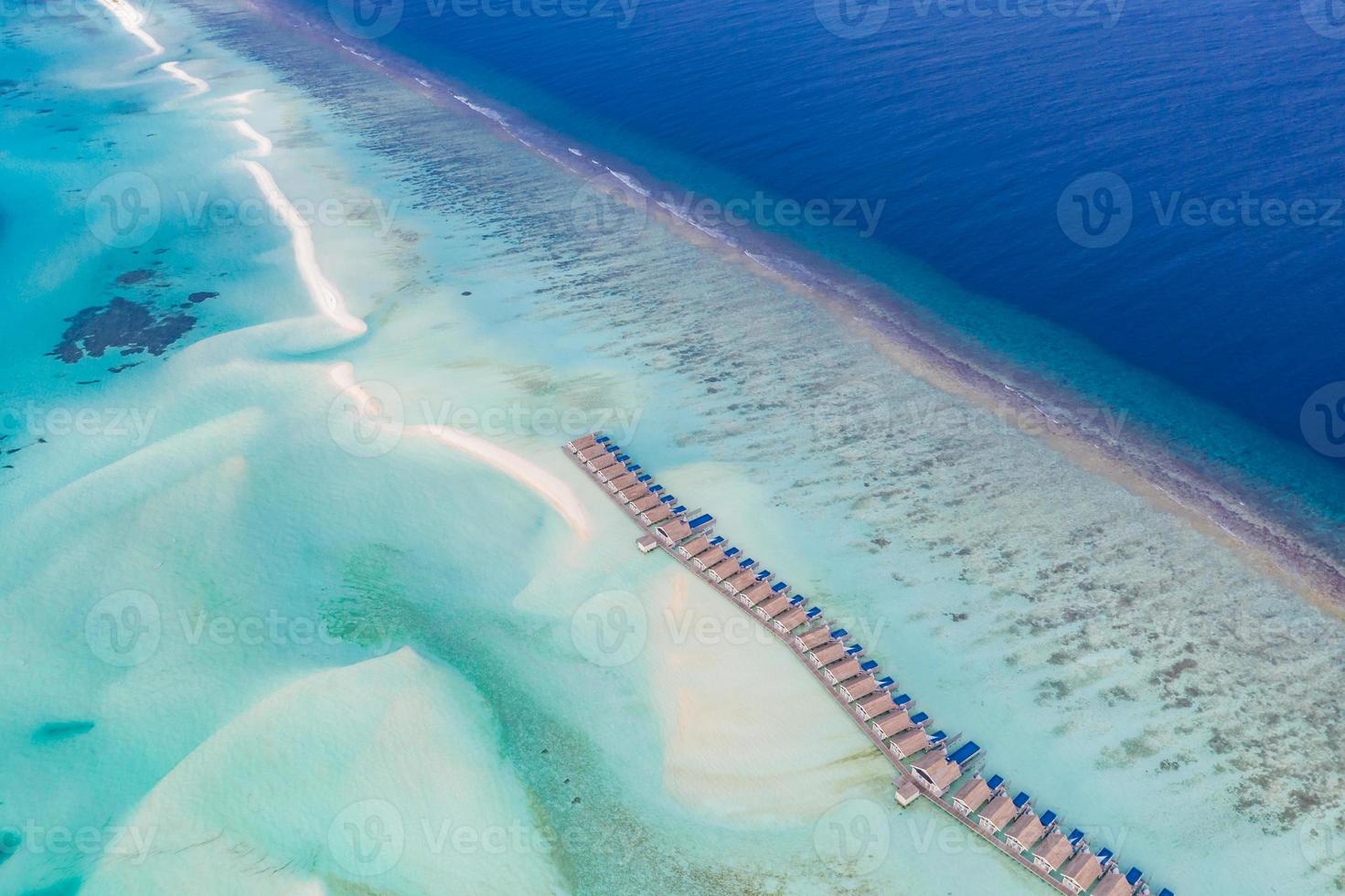 Aerial view on Maldives island. Beautiful sea and coral reef with luxury water villas. Tropical resort, amazing exotic landscape. Summer vacation beach and holiday scenery. Tourism destination photo