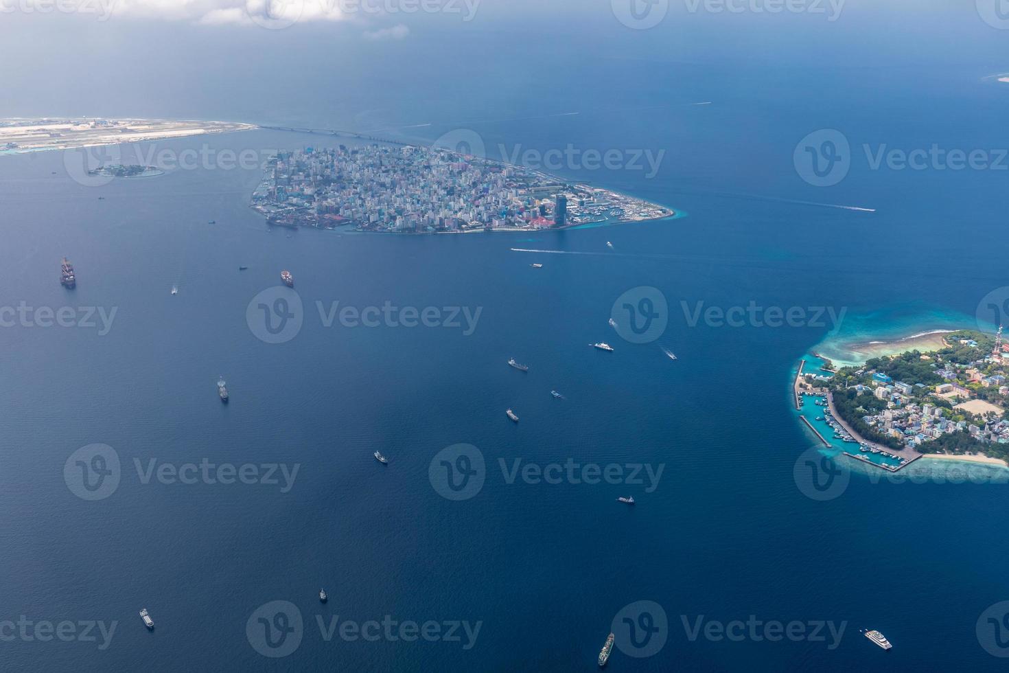 Aerial view of Maldives islands and atolls. Maldives tourism and travel background. Amazing blue sea, coral reef and atoll drone view. Beautiful nature landscape, seascape, exotic destination photo