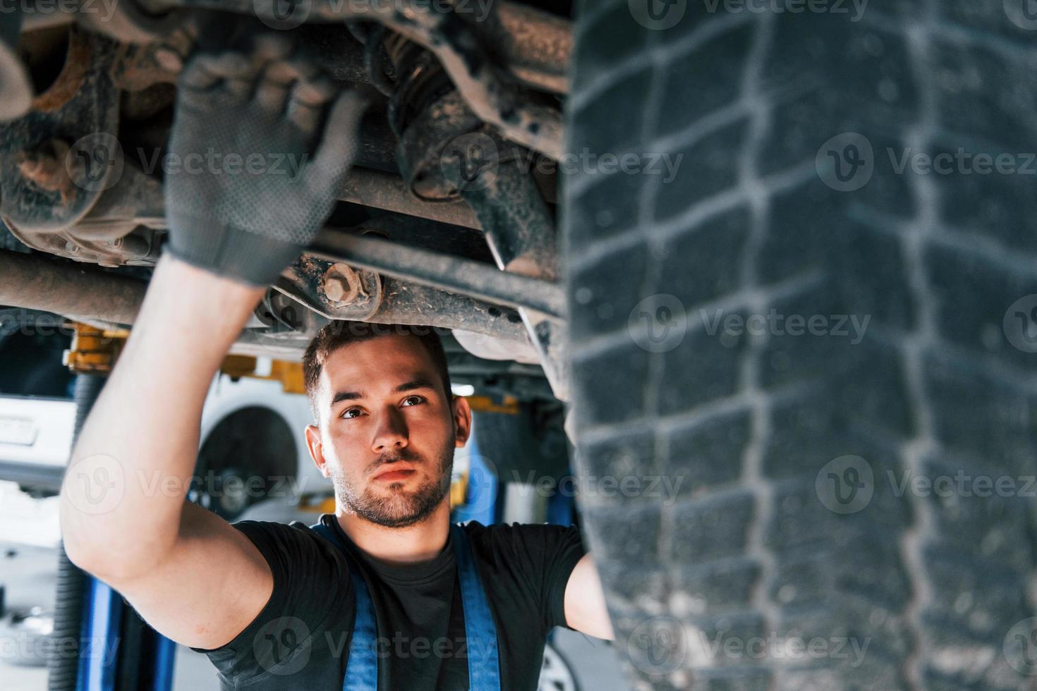 Auto mechanic working in garage. Repair service photo