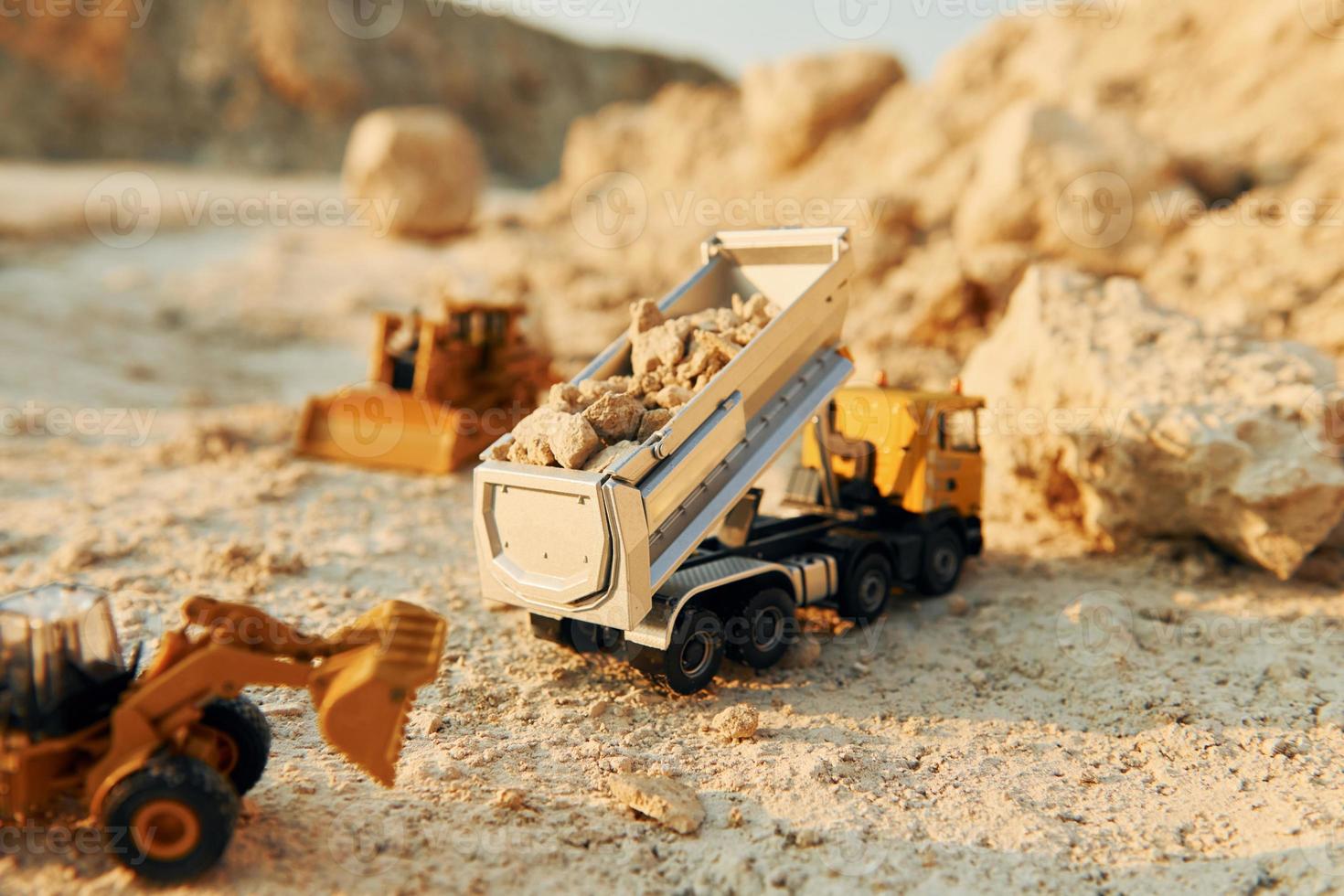 Loading vehicle miniatures outdoors on the borrow pit at daytime photo