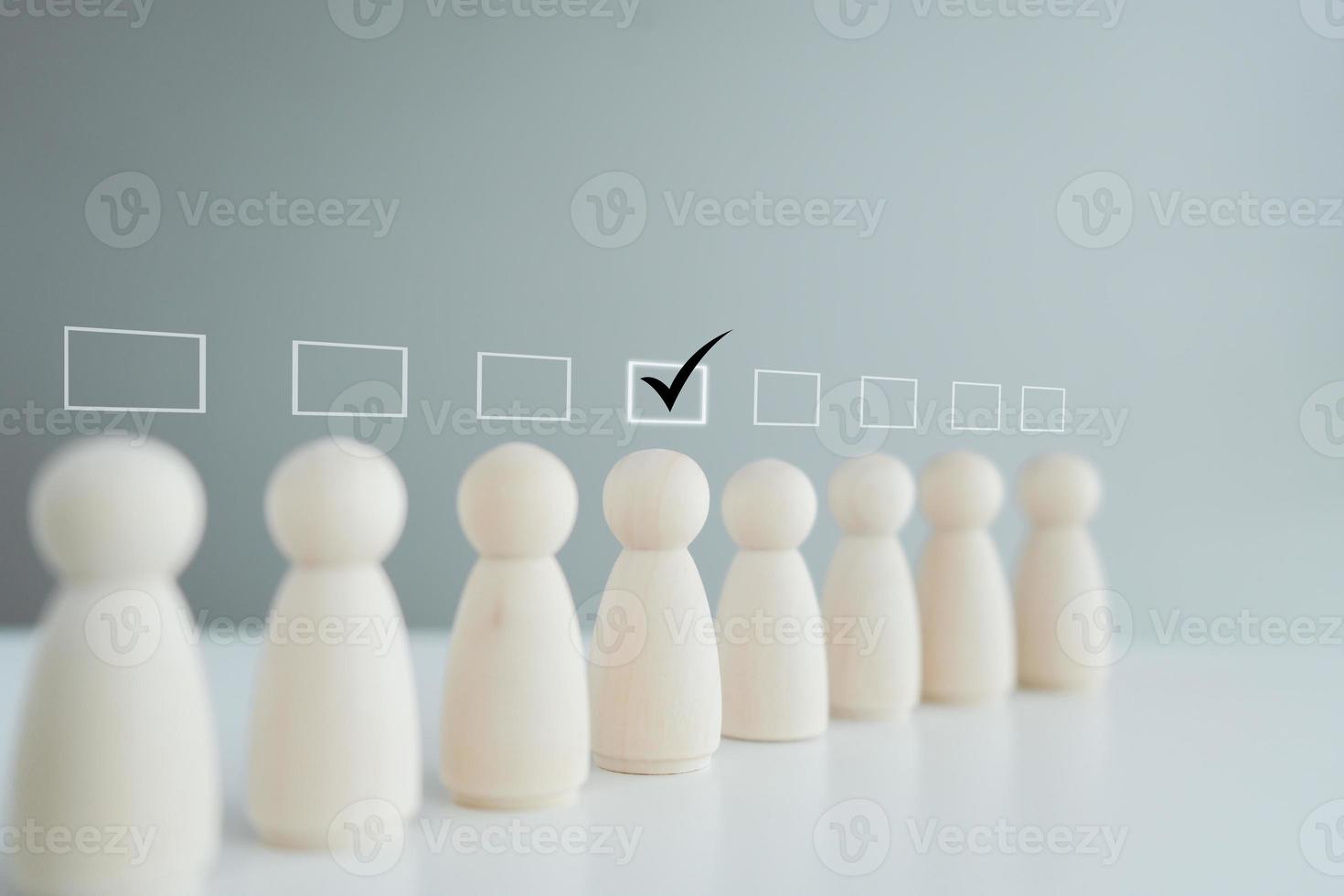 Business hiring and recruitment selection. Career opportunity. Human Resource Management. Check mark to choose wooden human figure for recruit to company. Choice of employee leader from the crowd. photo