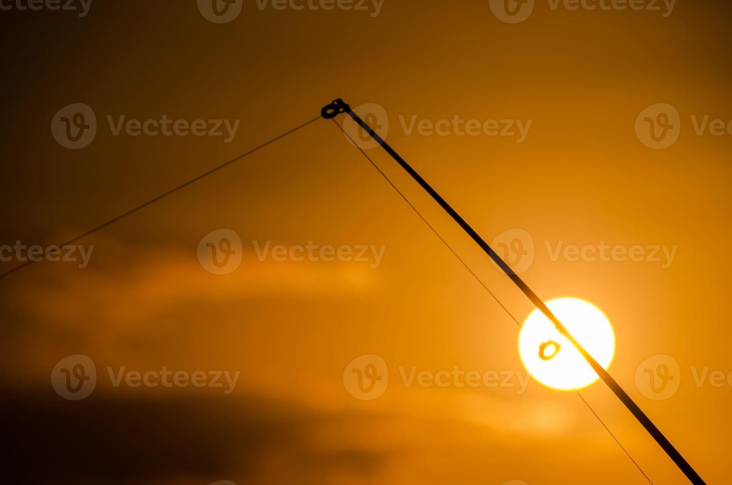 Fishing pole over the sunset photo