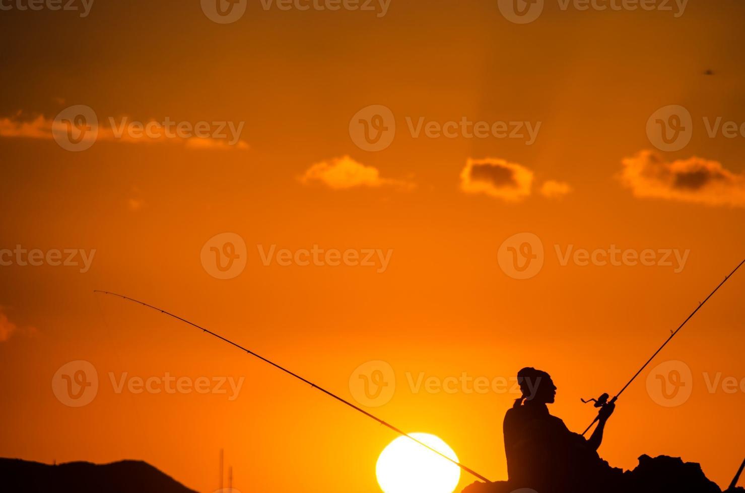 Fishing pole over the sunset photo