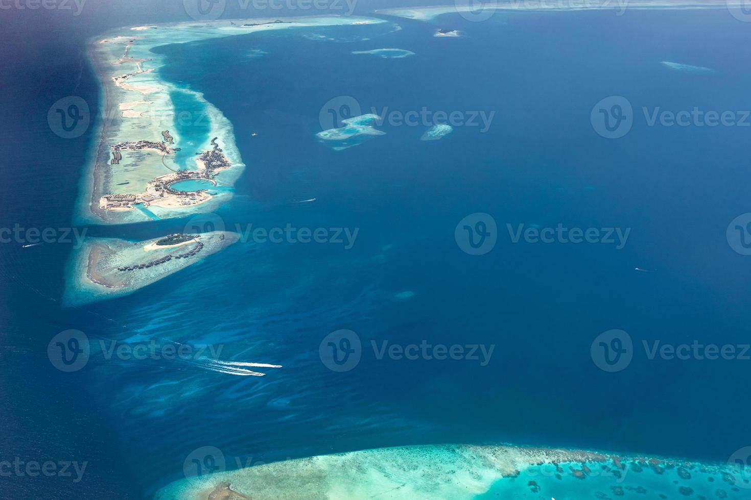 Aerial view of Maldives islands and atolls. Maldives tourism and travel background. Amazing blue sea, coral reef and atoll drone view. Beautiful nature landscape, seascape, exotic destination photo