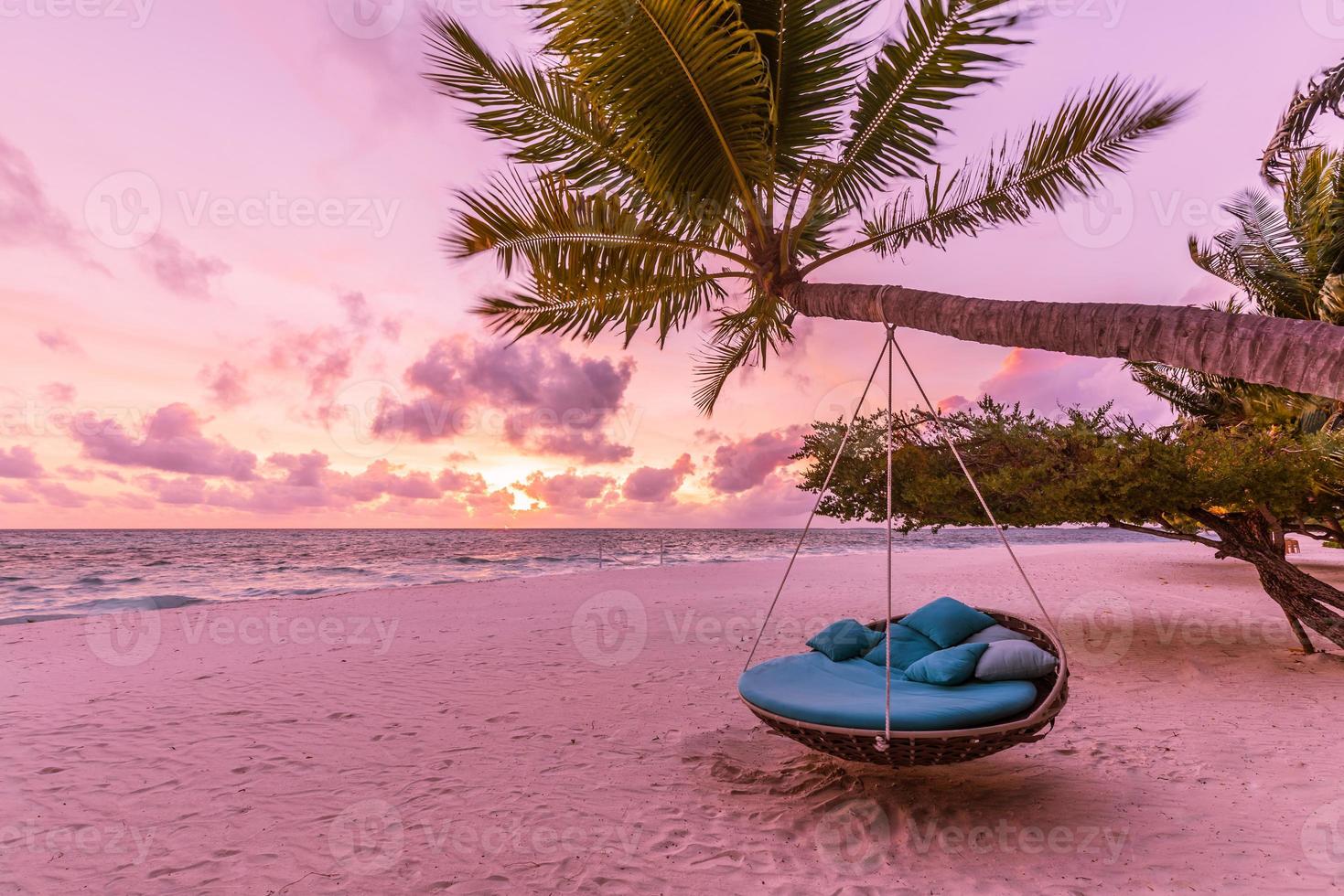 atardecer romántico en la playa. palmera con columpio colgando ante el majestuoso cielo de nubes. paisaje natural de ensueño, isla tropical paradisíaca, destino de pareja. costa de amor, arena de mar de primer plano. relajarse playa virgen foto