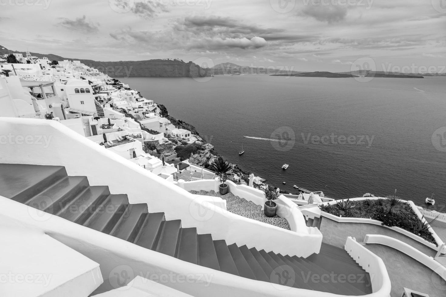 vista clásica en el pueblo de oia en la isla del volcán santorini en grecia. proceso dramático, foto en blanco y negro. vista al mar de la caldera, paisaje idílico