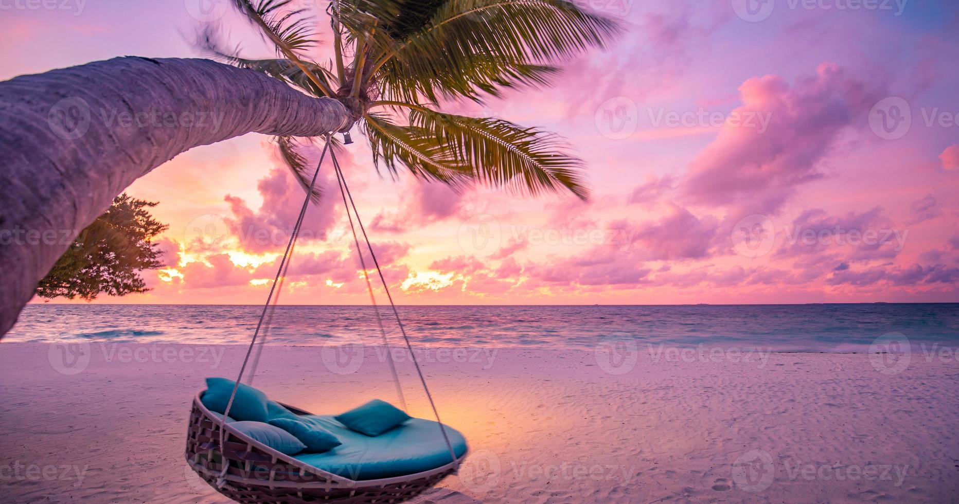 Tropical sunset beach as summer landscape with beach swing or hammock and white sand, colorful sky and sea shore. Beautiful beach banner vacation and summer holiday concept. Boost up color process photo