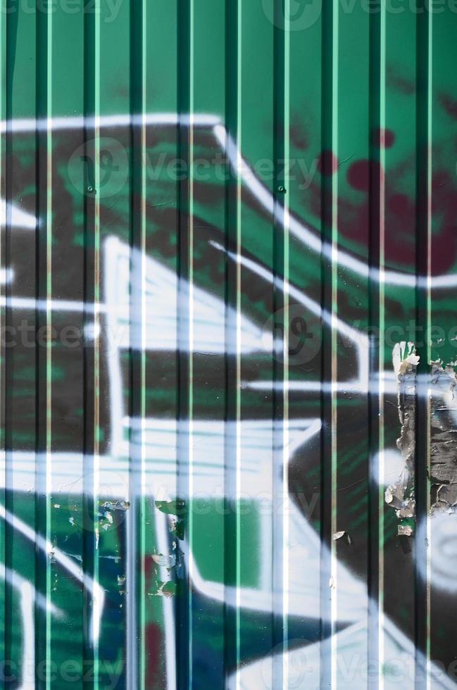 Fragment of graffiti drawings. The old wall decorated with paint stains in the style of street art culture. Colored background texture in green tones photo