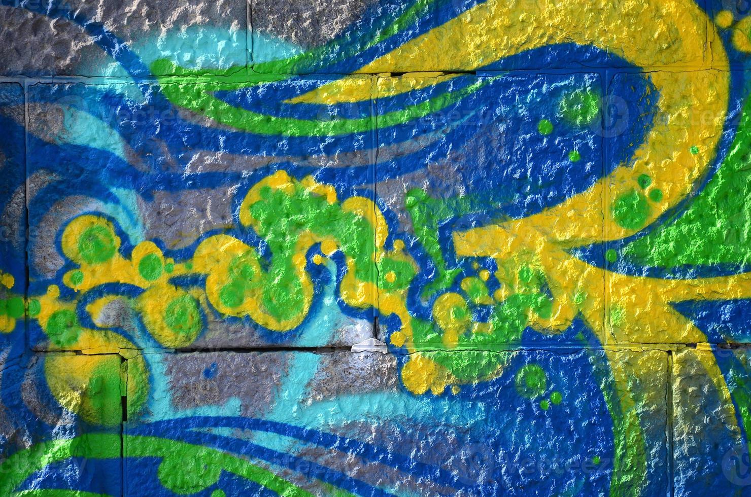Fragment of graffiti drawings. The old wall decorated with paint stains in the style of street art culture. Colored background texture in green tones photo
