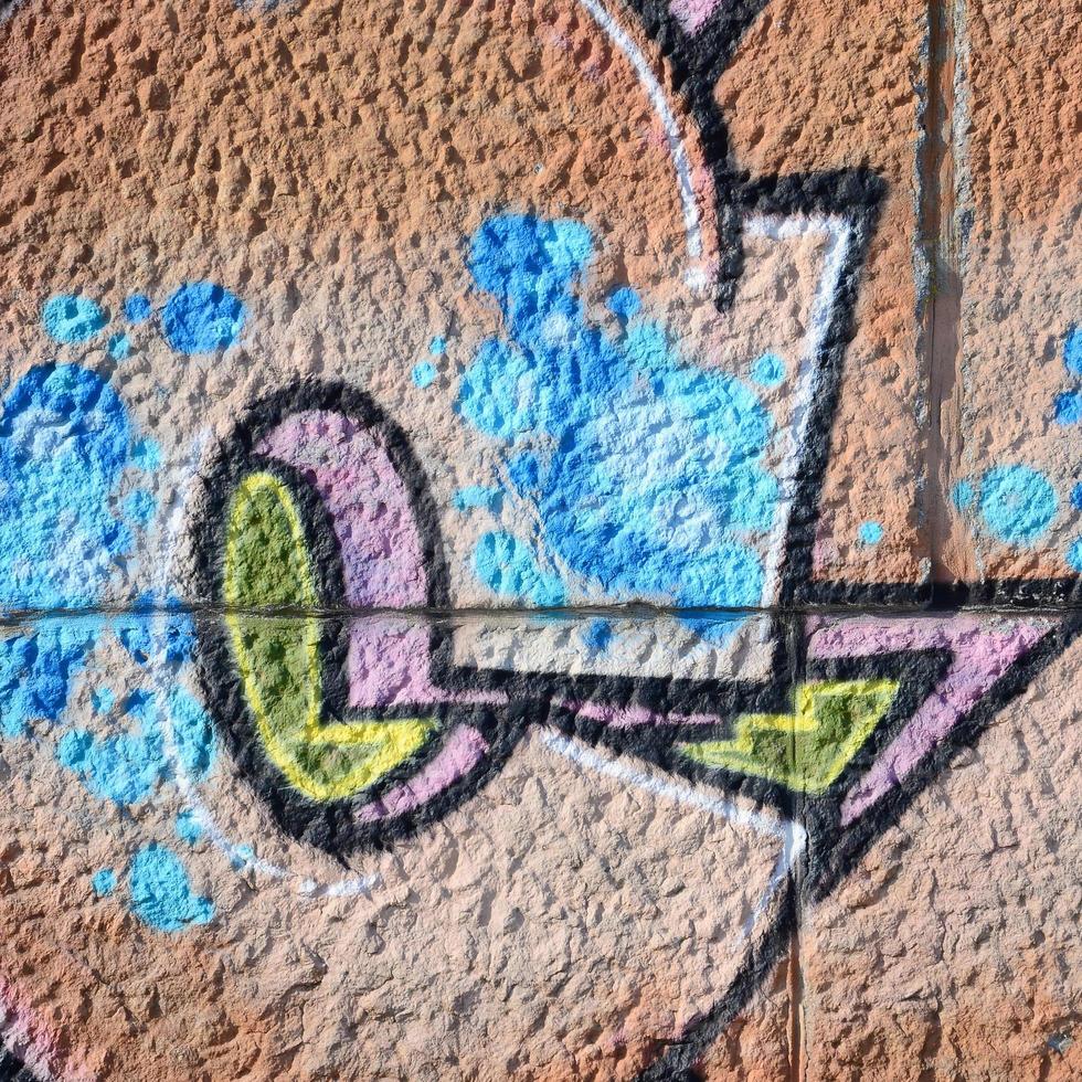 fragmento de dibujos de graffiti. la antigua muralla decorada con manchas de pintura al estilo de la cultura del arte callejero. textura de fondo coloreada en tonos cálidos foto