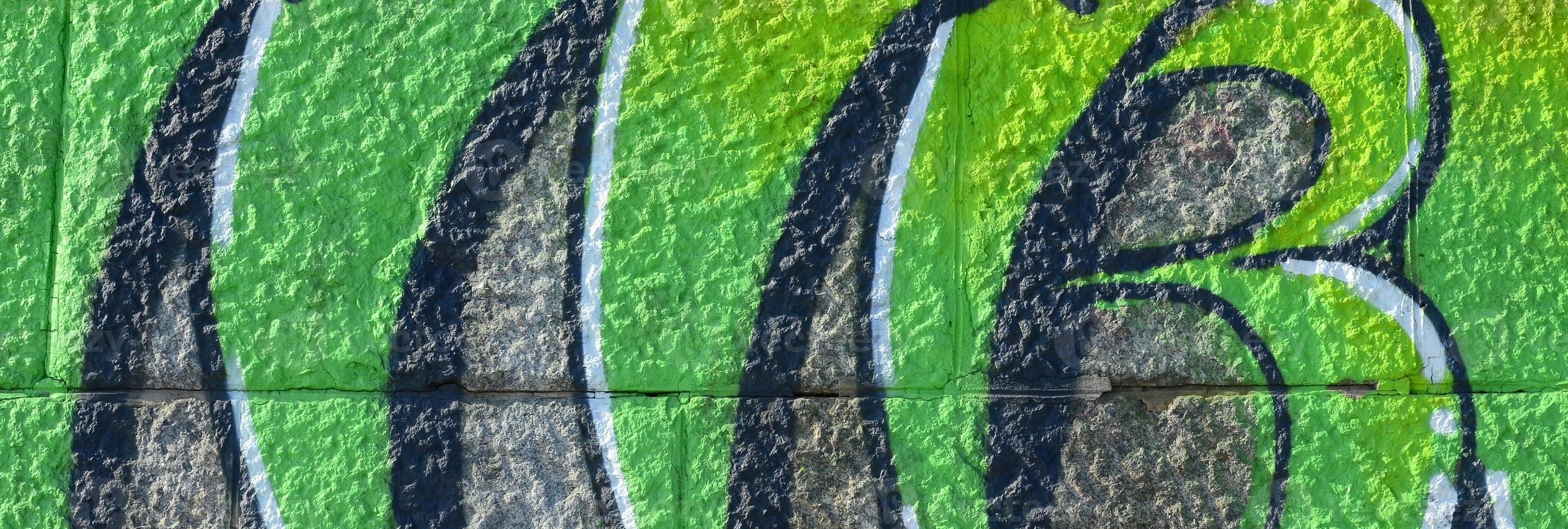 Fragment of graffiti drawings. The old wall decorated with paint stains in the style of street art culture. Colored background texture in green tones photo