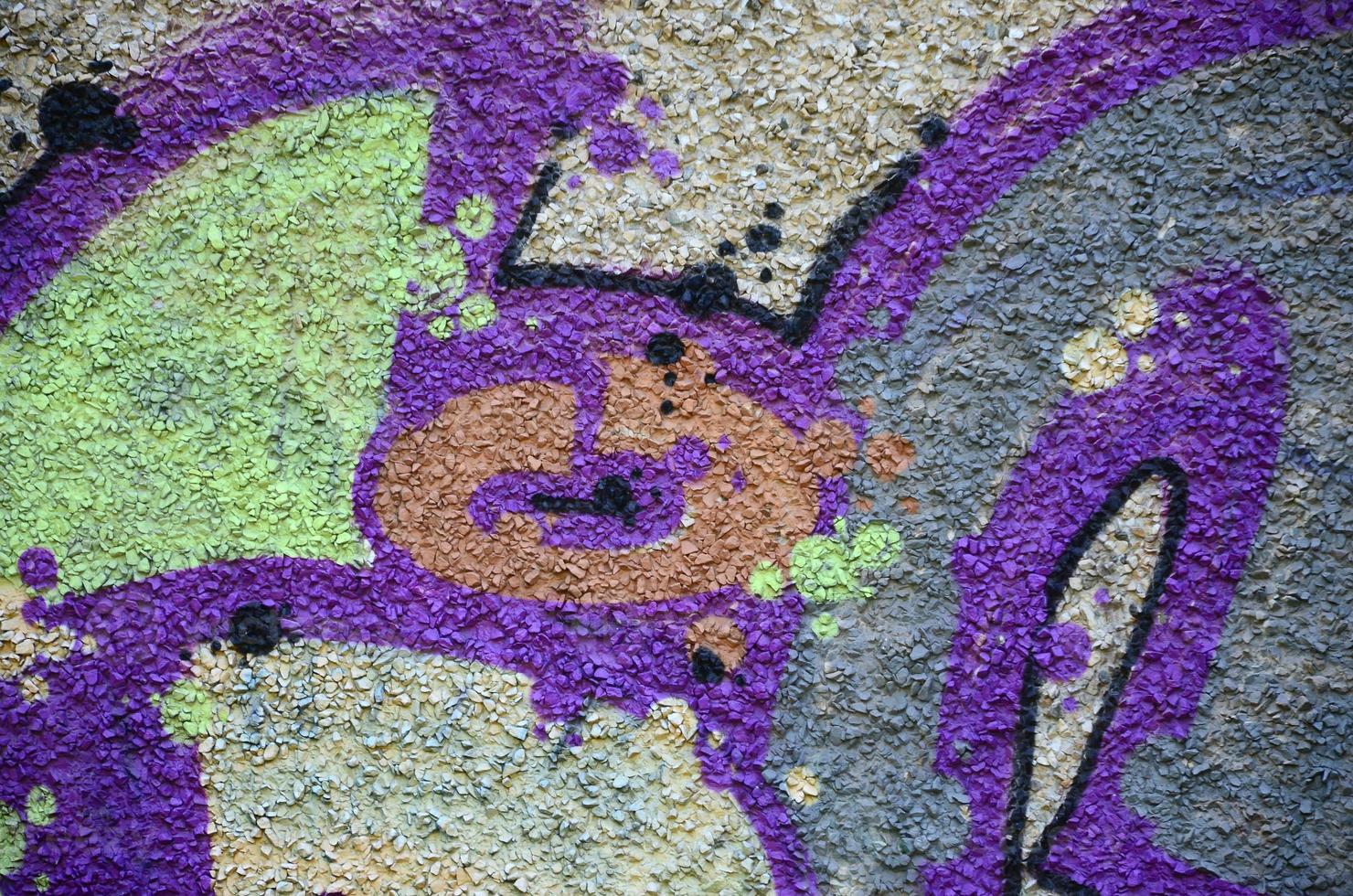 Fragment of graffiti drawings. The old wall decorated with paint stains in the style of street art culture. Colored background texture in warm tones photo