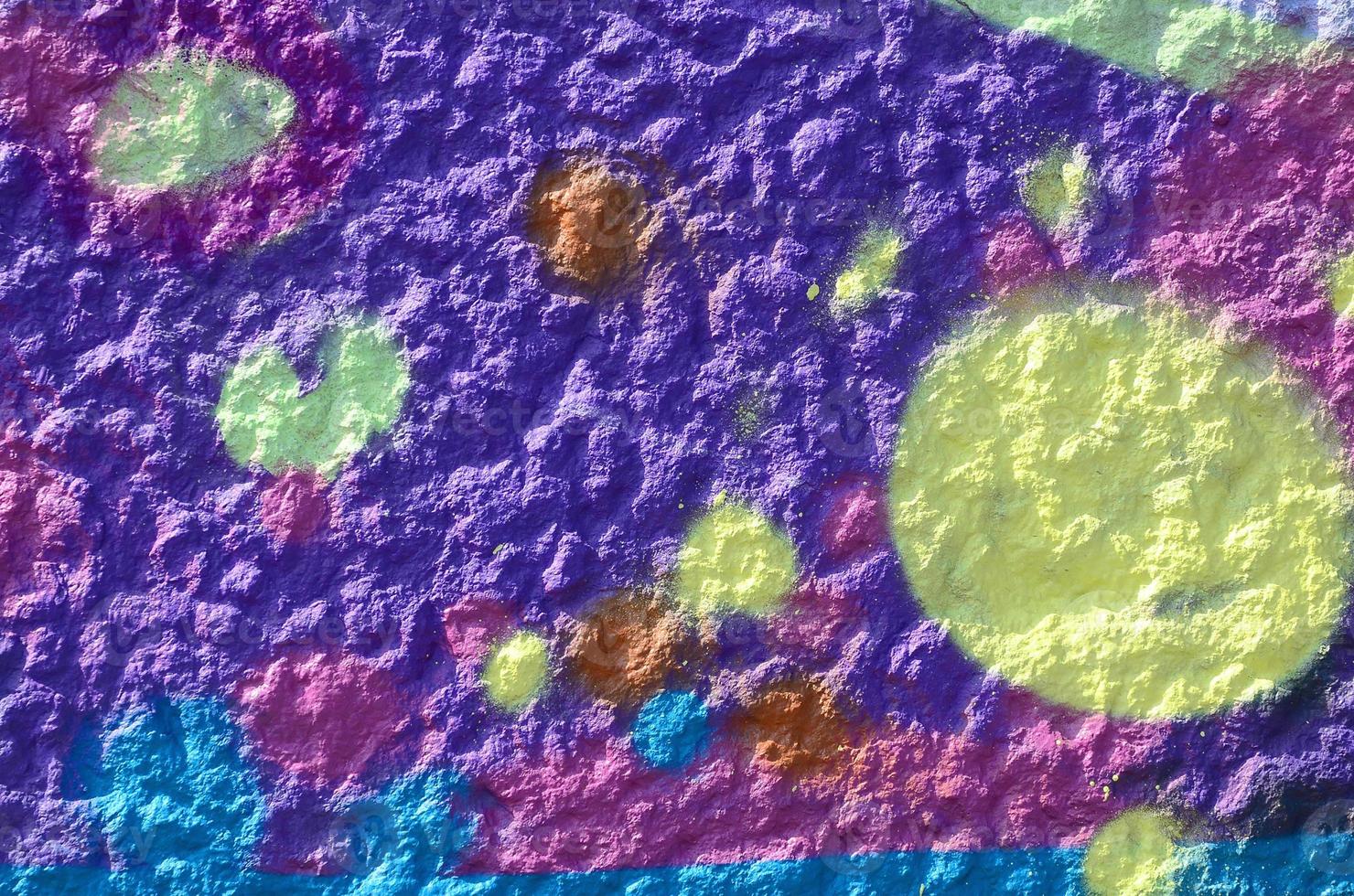 Fragment of graffiti drawings. The old wall decorated with paint stains in the style of street art culture. Multicolored background texture photo
