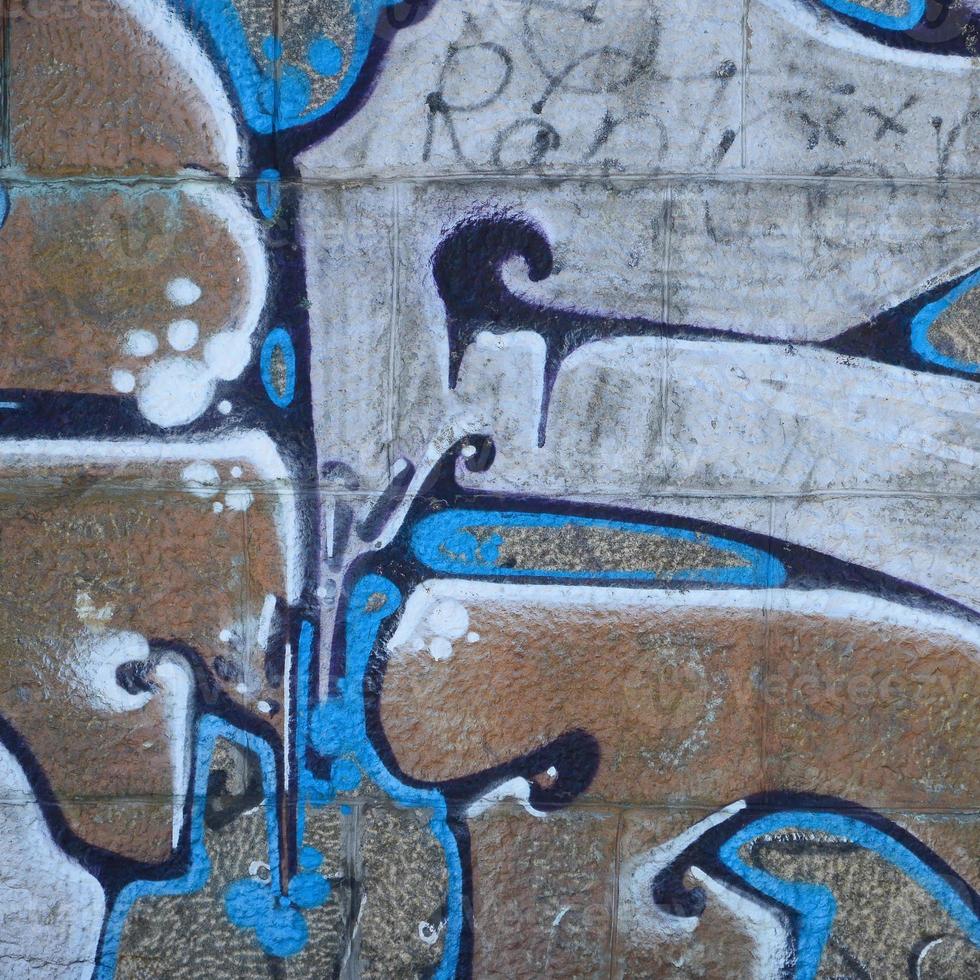 fragmento de dibujos de graffiti. la antigua muralla decorada con manchas de pintura al estilo de la cultura del arte callejero. textura de fondo coloreada en tonos cálidos foto