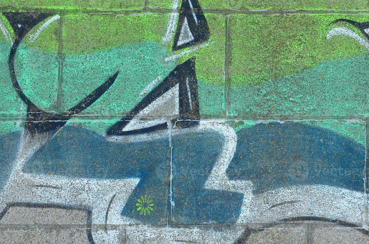 Fragment of graffiti drawings. The old wall decorated with paint stains in the style of street art culture. Colored background texture in green tones photo