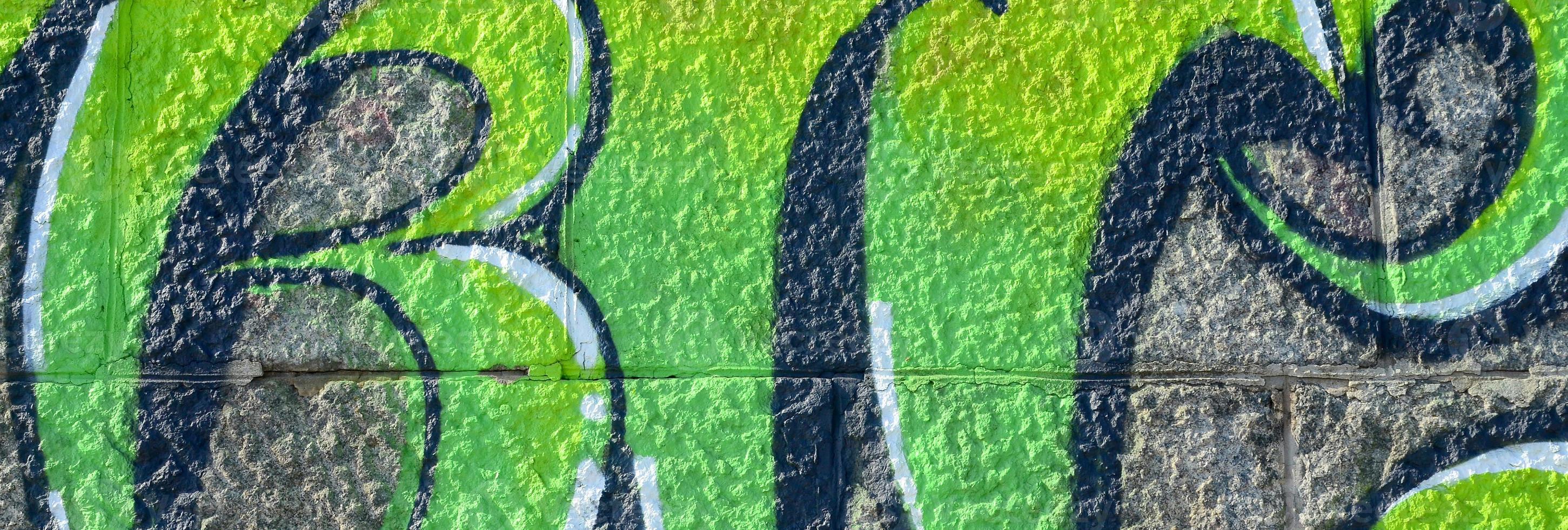 Fragment of graffiti drawings. The old wall decorated with paint stains in the style of street art culture. Colored background texture in green tones photo