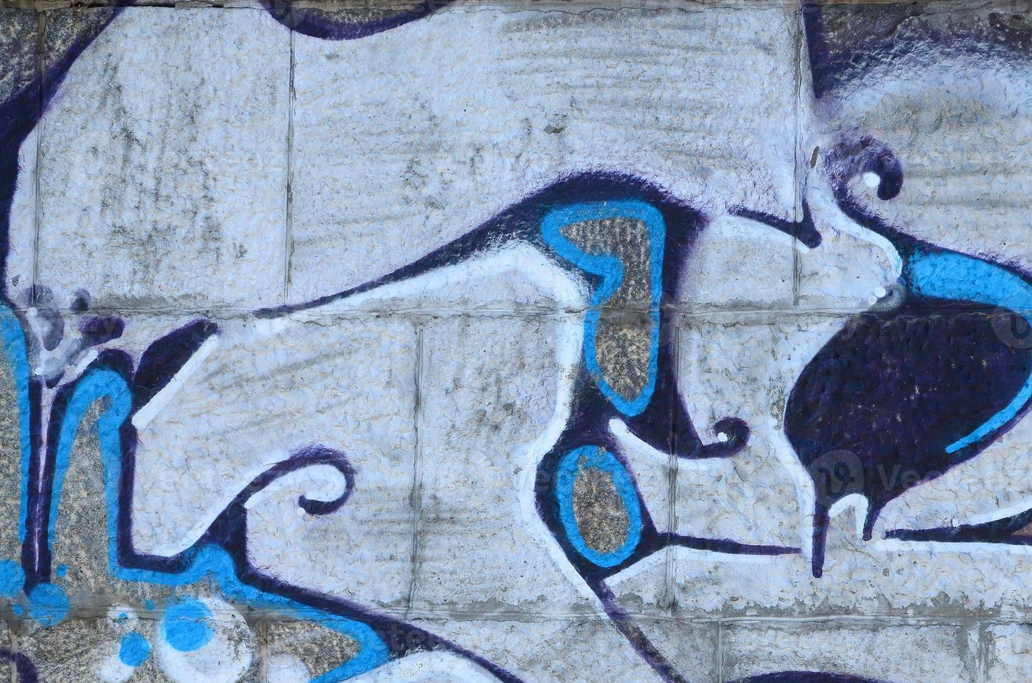 Fragment of graffiti drawings. The old wall decorated with paint stains in the style of street art culture. Colored background texture in warm tones photo
