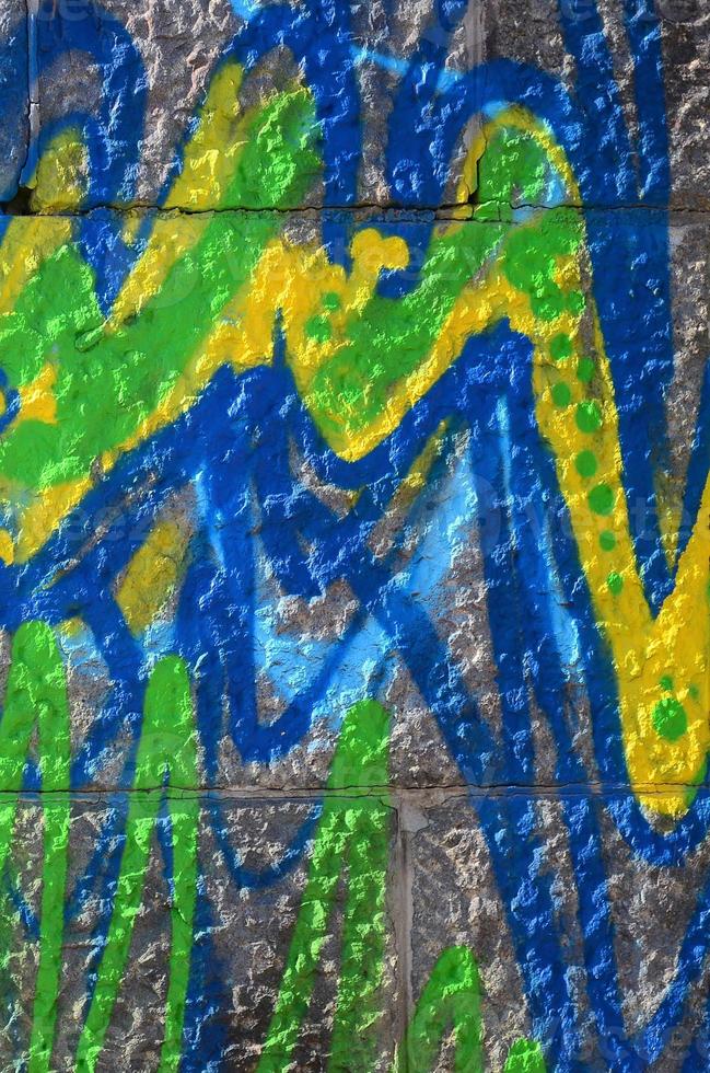 Fragment of graffiti drawings. The old wall decorated with paint stains in the style of street art culture. Colored background texture in green tones photo