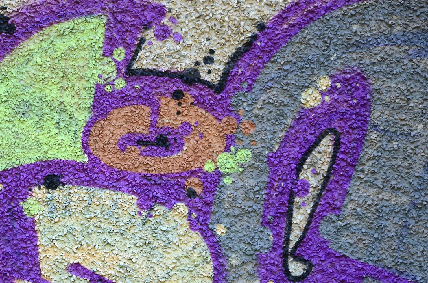 Fragment of graffiti drawings. The old wall decorated with paint stains in the style of street art culture. Colored background texture in warm tones photo