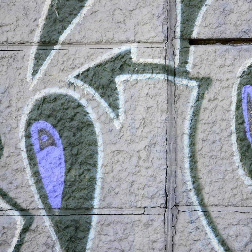 Fragment of graffiti drawings. The old wall decorated with paint stains in the style of street art culture. Colored background texture in purple tones photo