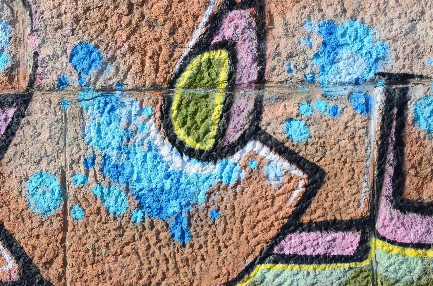 fragmento de dibujos de graffiti. la antigua muralla decorada con manchas de pintura al estilo de la cultura del arte callejero. textura de fondo coloreada en tonos cálidos foto