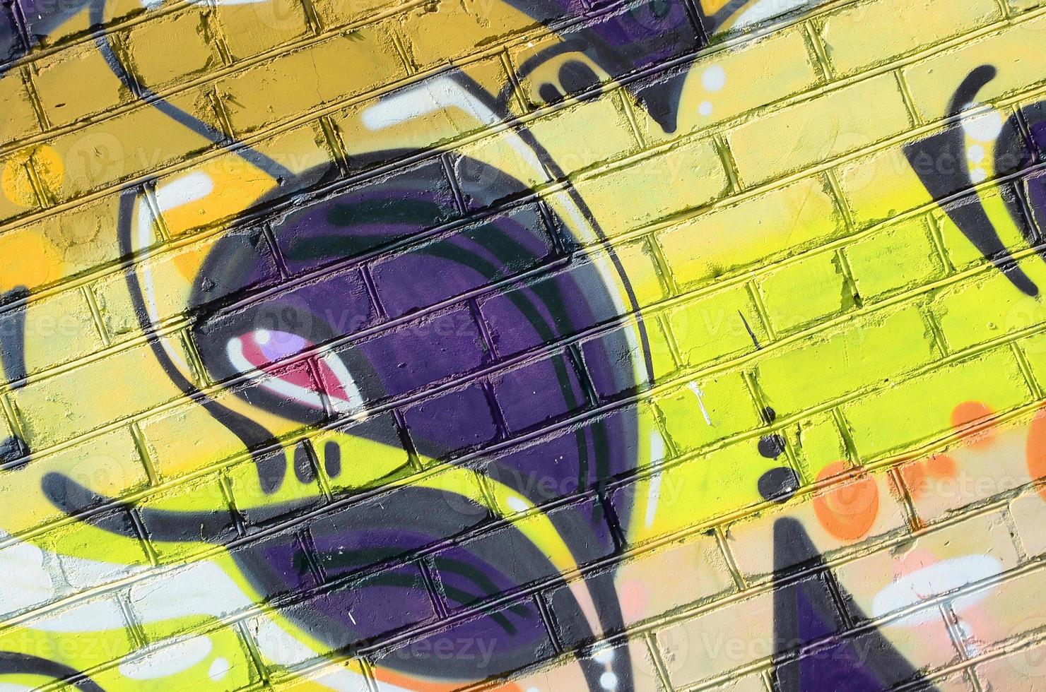 Fragment of graffiti drawings. The old wall decorated with paint stains in the style of street art culture. Colored background texture in warm tones photo