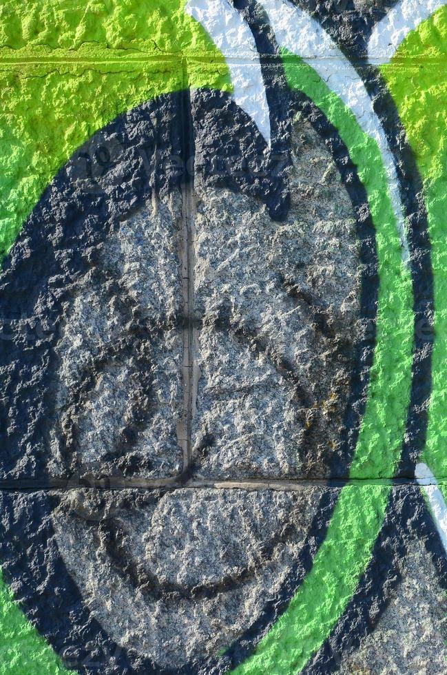 Fragment of graffiti drawings. The old wall decorated with paint stains in the style of street art culture. Colored background texture in green tones photo