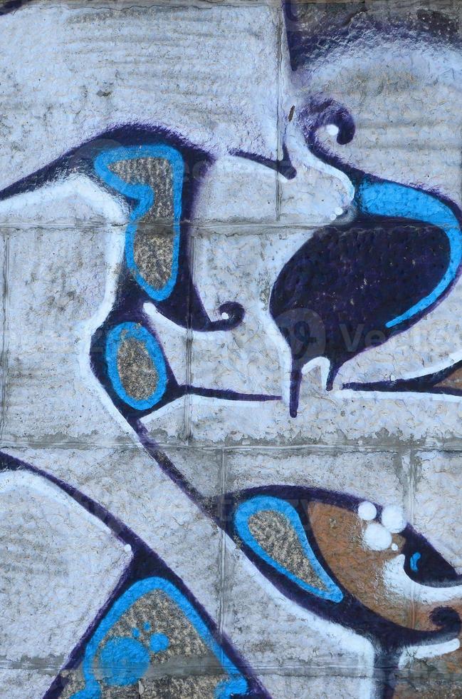 fragmento de dibujos de graffiti. la antigua muralla decorada con manchas de pintura al estilo de la cultura del arte callejero. textura de fondo coloreada en tonos cálidos foto