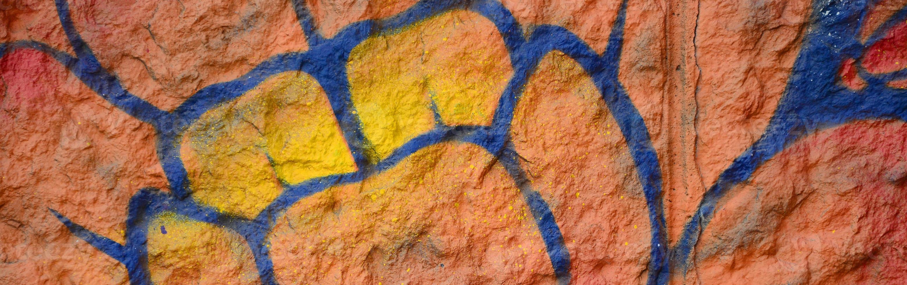 Fragment of graffiti drawings. The old wall decorated with paint stains in the style of street art culture. Orange flower photo