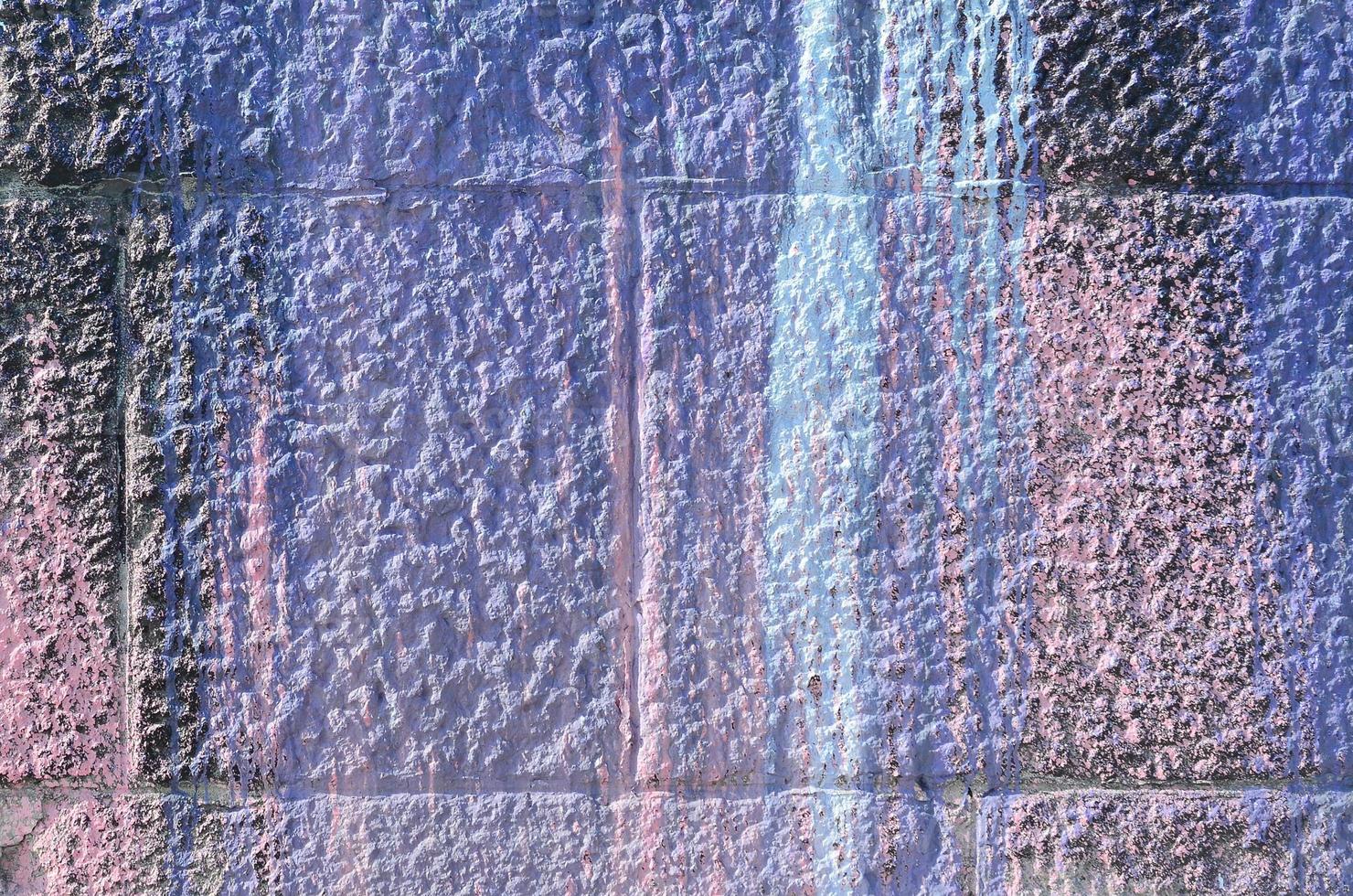 Fragment of graffiti drawings. The old wall decorated with paint stains in the style of street art culture. Colored background texture in purple tones photo