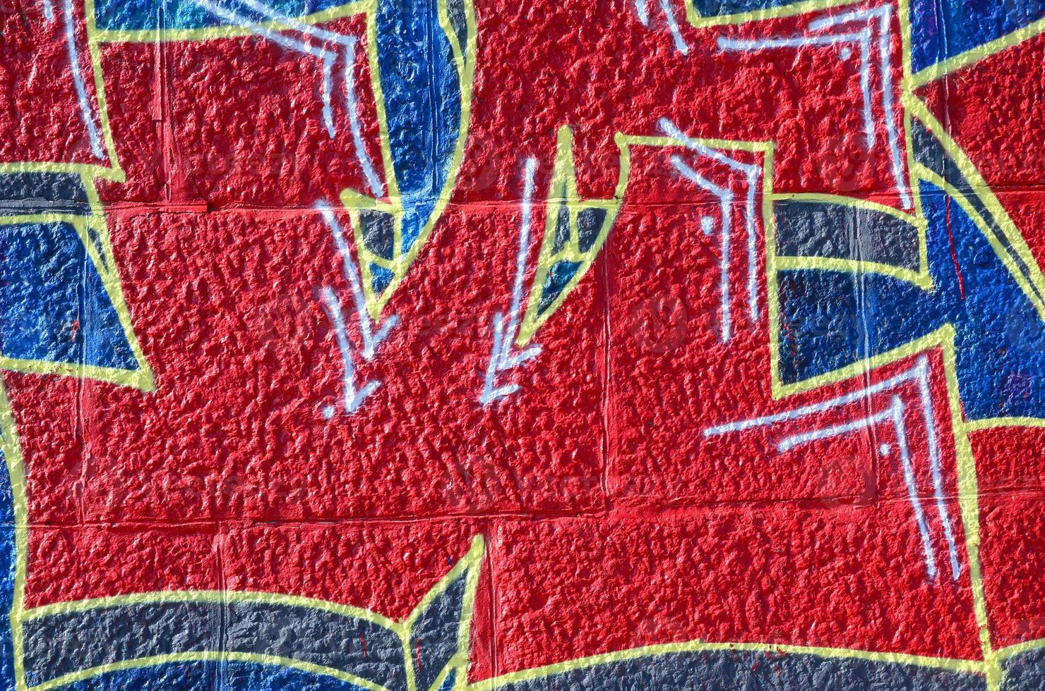 Fragment of graffiti drawings. The old wall decorated with paint stains in the style of street art culture. Colored background texture in warm tones photo