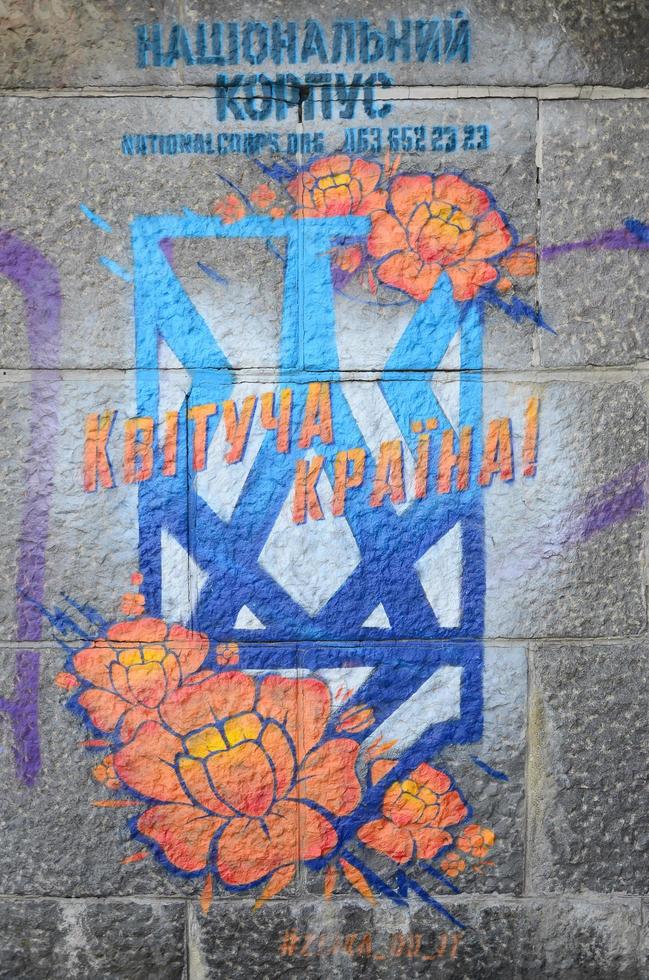 fragmento de dibujos de graffiti. la antigua muralla decorada con manchas de pintura al estilo de la cultura del arte callejero. flor naranja foto