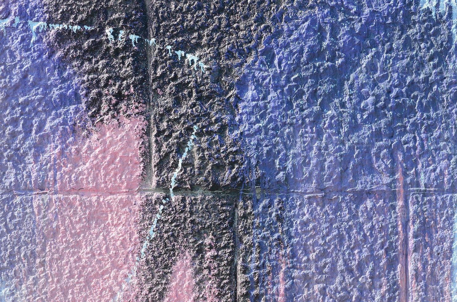 Fragment of graffiti drawings. The old wall decorated with paint stains in the style of street art culture. Colored background texture in purple tones photo